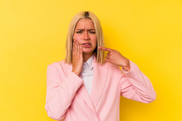 Young venezuelan woman isolated on yellow background having a strong teeth pain, molar ache.