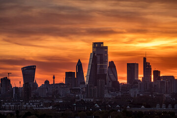 Fototapeta na wymiar Colorful sunset behind the modern skyline with the diverse, corporate skyscrapers of the City of London, United Kingdom