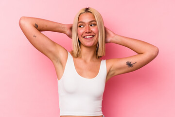 Fototapeta premium Young venezuelan woman isolated on pink background feeling confident, with hands behind the head.
