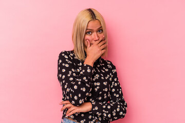 Young venezuelan woman isolated on pink background scared and afraid.