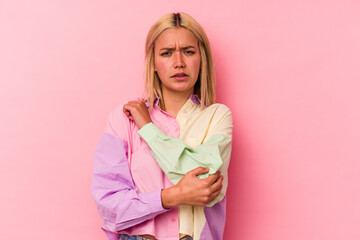 Young venezuelan woman isolated on pink background massaging elbow, suffering after a bad movement.