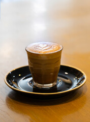 Decorated glass of Coffee Piccolo Latte milk froth design