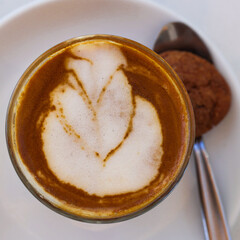 Decorated glass of Coffee Piccolo Latte milk froth design