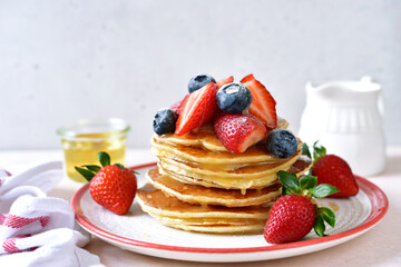 Hot homemade delicious pancake with fresh strawberry and honey.