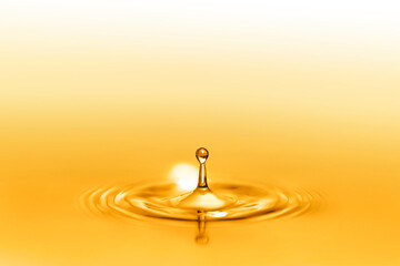 Close up on drop splash of a healthy extra-virgin oil full of oligo elements and vitamins creating...
