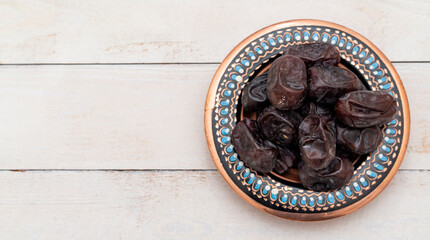 Fresh date fruits in ottoman handmade bowl on wooden background. Healthy food. Fast food. Food for vegetarians. Side view.  Ramadan ( ramazan ) food.