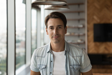Close up profile picture of young Caucasian businessman pose in own modern office show leadership...