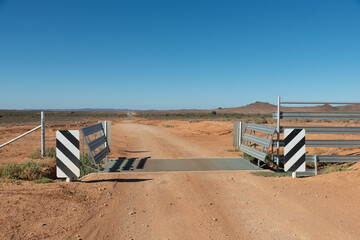 Cattle barrier grid at the dirt road in a remote area of Australian Outback near Mount Gipps Station, NSW