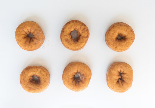 High angle view of six cinnamon donuts on white background