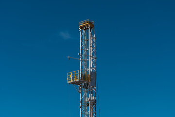 Fototapeta na wymiar top of drilling tower with blue sky background.