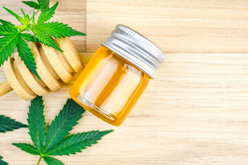 CBD Cannabis infused Honey with dipper spoon jar Marijuana leafs on wooden table