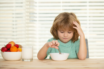 Child eating healthy food at home. Baby eat soup with spoon.