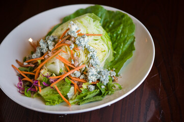 Wedge salad. Classic American salad with iceberg lettuce, blue cheese dressing, red onions, bacon lardons, Parmesan cheese, olive oil, lemon juice, salt and pepper. A Fine dining restaurant classic.