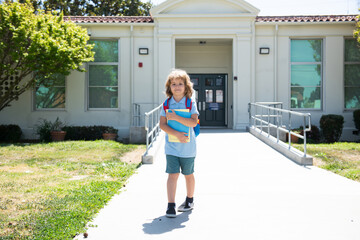 Back to school. Pupil of primary school on the way to study. First grader with school bag. Beginning of lessons. A boy from an elementary school with a backpack on the street. Full length.