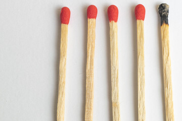 Five wooden matches one burned