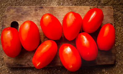 closed up on fresh Italian type tomatoes on wooden board 