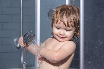 Child having fun to bath. Baby showering. Portrait of kid bathing in a bath with foam.