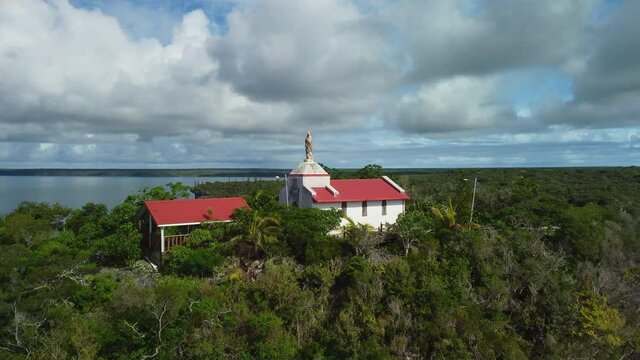 Aerial view tilting over the Chapelle Notre Dame de Lourdes, in Lifou, New Caledonia - rising, drone shot