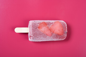 top view fresh Brazil berry flavor popsicle with strawberry slices  on a rose red background