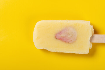 fresh durian flavor popsicle with slice of strawberry on a yellow background