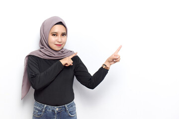 Smiling and pointing copyspace of Young beautiful muslim asian women dress Veil(Hijab) and black shirt isolated on white background