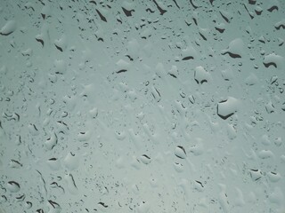 Rain drops on the car glass when it rains.