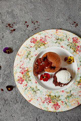 Chocolate Fondant - Chocolate Cakes with Liquid Centers served hot with ice cream. Molten Lava Chocolate Cake or Melting Chocolate on textured gray table.