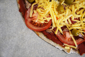 Pizza with beef on baking paper prepared for baking. Healthy gluten-free pizza. Gluten-free cooking class. Banner with copy space. 