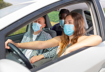 Positive woman and man in protective mask in car during common trip