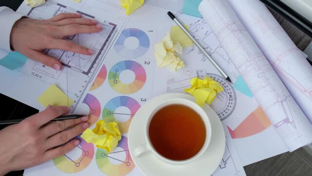 4k Architect designer Interior creative working hand drawing blueprints protractor in office workplace on desk architectural plan of the house, color palette. Female architect. Workspace