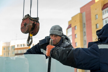 A portrait of a fitter in a blue jacket at the hook