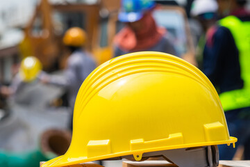 Yellow helmet hard hat safety on table blurry employee background, Labor day concept