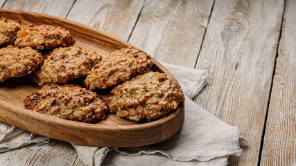 Delicious homemade oatmeal cookies. Homemade gluten and sugar free recipe. Rustic wooden background and linen napkin. Tasty and healthy sweets. Copy space. Food banner format.