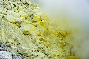 Ijen volcano crater and sulphur mining. Beautiful Landscape mountain and green lake with smoke sulfur in the morning in a Kawah Ijen volcano. Beautiful landmark from East Java, Indonesia