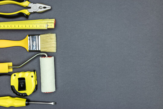 various working tools for construction and home repair works on dark grey background. top view
