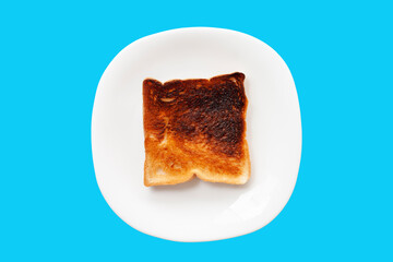 Burnt toast in white plate isolated on blue background included clipping path.