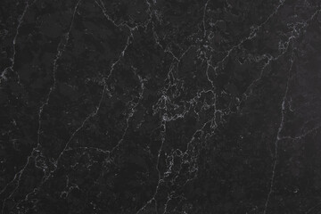 Obraz na płótnie Canvas Closeup of a dark marble looking quartz slab that contains a two-toned charcoal grey background with soft light grey subtle veins