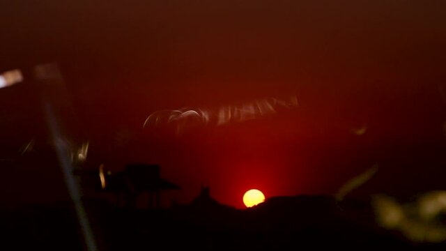 Por do sol conceitual em comp&oacute;sito com fuma&ccedil;a de incenso com a igreja Nossa Senhora da Penha (n&atilde;o reconhec&iacute;vel pela imagem pela dist&acirc;ncia). Filmado a partir da Ilha do Fund&atilde;o, UFRJ -  Rio de Janeiro.