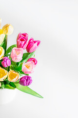 Beautiful yellow purple tulips on a light background. Fresh spring flowers. Copy space for text. Floral summer concept. Vertical photo.