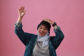 Fashion portrait of young beautiful asian muslim woman with wearing hijab isolated on pink background