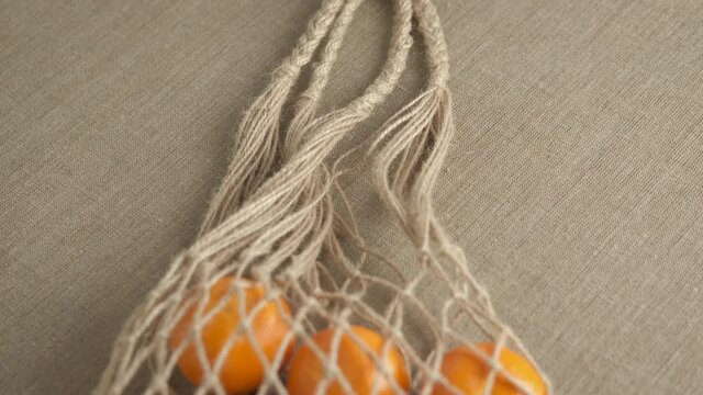 Organic tangerine on the table. A view of a bio zero waste net bag with mandarines on the table.