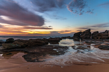 Sunrise at the seaside with pastel coloured clouds