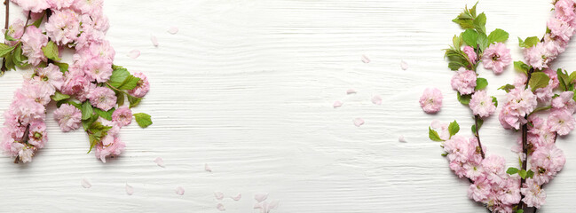 Beautiful blossoming branches on white wooden background with space for text