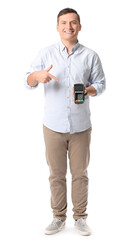 Young man with payment terminal on white background