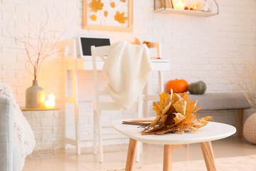 Autumn leaves on table in modern room