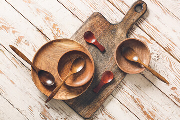 Spoons and bowls on wooden background