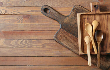 Spoons and chopping boards on wooden background