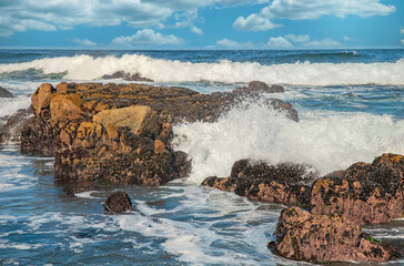 Beautiful seascape of the Pacific coast in California, waves, rocks, sky, sun. Concept, perfect postcard and guide.