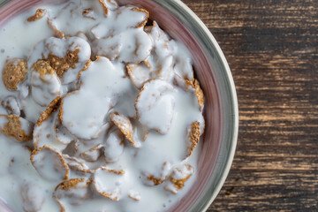 Fototapeta na wymiar Whole grain glazed flakes with yogurt in plate. Healthy breakfast, whole grain muesli in a bowl