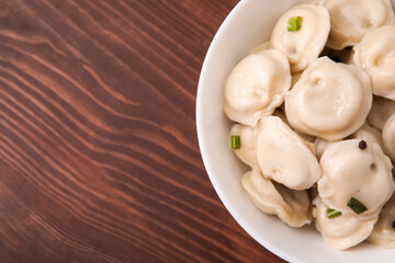Fototapeta na wymiar Bowl with tasty dumplings on wooden background